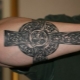 Miesten tatuointi ristin muodossa käsivarteen